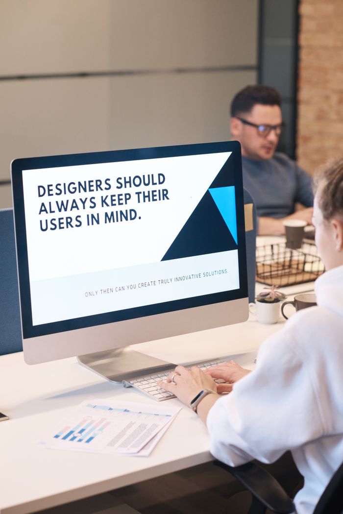 A concentrated designer is working on a user-centered project in a contemporary office setting.
